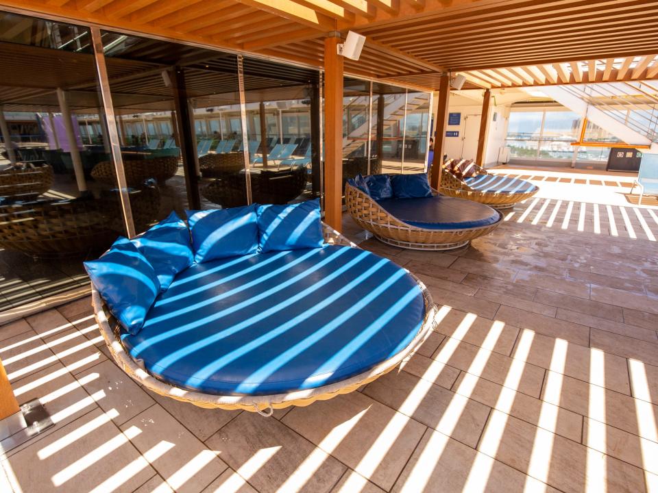 Empty lounge chairs under a shadded area.