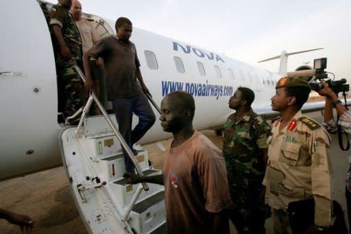 Foreigners captured whilst investigating debris from recent fighting between Sudan and South Sudan in the Heglig oilfield area are escorted off an airplane by Sudanese soldiers in Khartoum. The foreigners identified as a British, a Norwegian, a South African and a South Sudanese were flown to Khartoum for "more investigation", according to an army spokesman