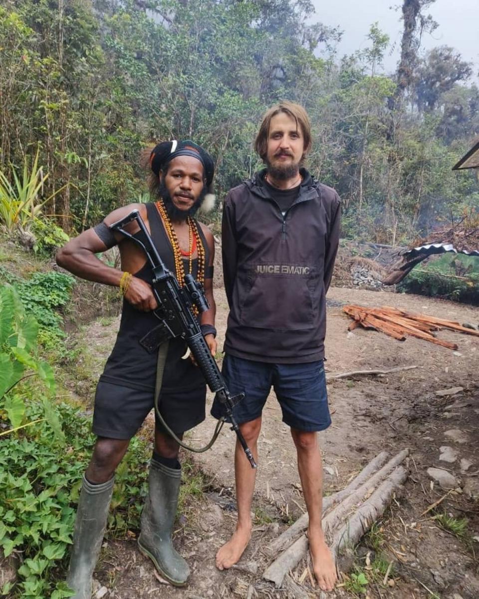 The former pilot stands next to a West Papua Liberation Army rebel (Supplied)