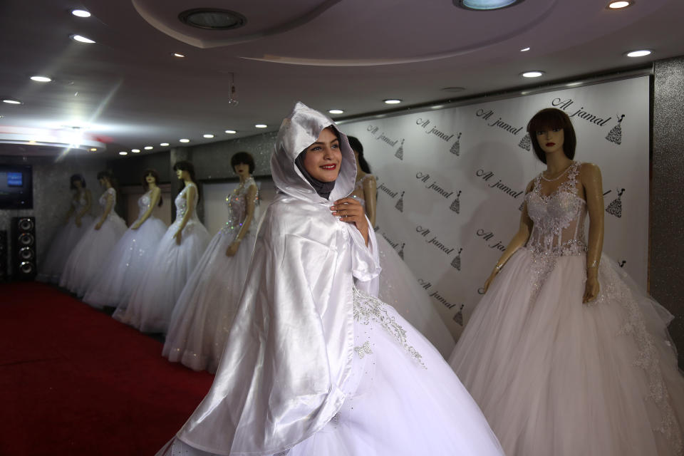 Hana Abu El-Roos, 18, a Palestinian high school student, tries on a dress as she prepares for her wedding, in a store in Gaza City, Nov. 26, 2018. El-Roos plans to get married this summer but can't find items she needs for her wedding in any of Gaza's shops. "I haven't picked my wedding dress yet," said El-Roos, who is also busy preparing for her final high school exams. "I am confused. My sisters are helping me." (Photo: Samar Abo Elouf/Reuters)