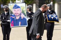 French Prime Minister Jean Castex walks past a portrait of police officer Eric Masson, who was killed during an anti-drug operation, during an hommage ceremony in Avignon, southern France, Tuesday, May 11, 2021. It was the latest of several attacks targeting French police that have angered police unions and become a political issue ahead of regional elections in June and next year's presidential election. France's prime minister is proposing tougher and faster punishment for people who attack police, as the government pays a national tribute to the latest police officer killed in the line of duty. (Nicolas Tucat, Pool via AP)