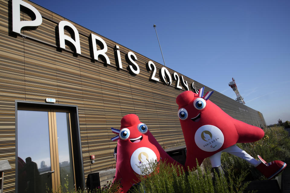 Mascots of the 2024 Paris Olympic Games, left, and Paralympics Games, a Phrygian cap, pose during a preview in Saint Denis, outside Paris, Thursday, Nov. 10, 2022. The soft bright red cap, also known as a liberty cap, is an updated version of a conical hat worn in antiquity in places such as Persia, the Balkans, Thrace, Dacia and Phrygia, where the name originates, in modern day Turkey. It later became a symbol of the pursuit of liberty in the French Revolution and is still worn by the figure of Marianne, the national personification of France since that time. (AP Photo/Christophe Ena)