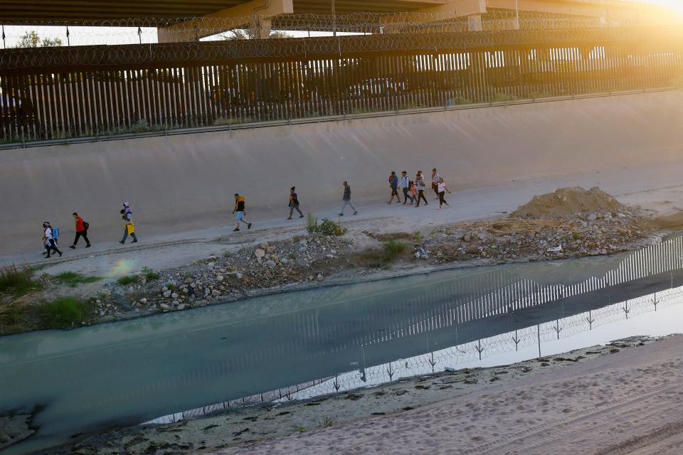 Asylum-seeking migrants, mostly from Venezuela, walk near the border wall after crossing the Rio Bravo river to turn themselves in to U.S. Border Patrol agents to request asylum in El Paso, Texas, U.S. (REUTERS)