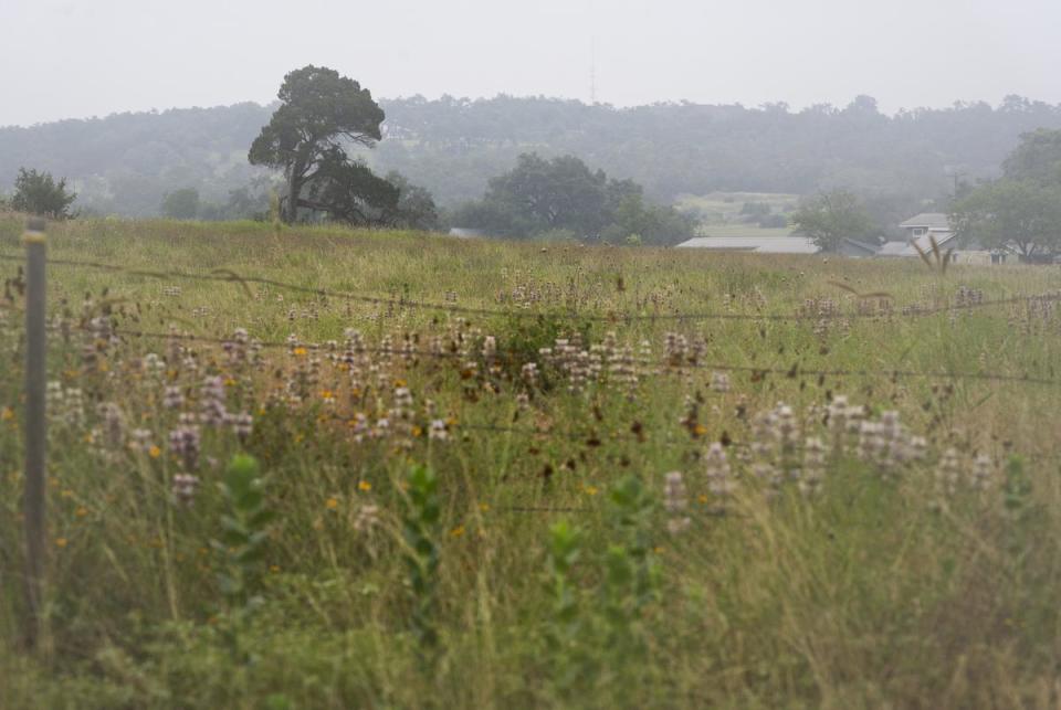 A barbed wire fence in Comal County nearly halfway between New Braunfels and Bulverde, on June 15, 2023. Doug Harrison’s application for a wastewater treatment plant on his 500-plus-acre plot of land in Comal County stirred controversy as residents have raised environmental concerns.