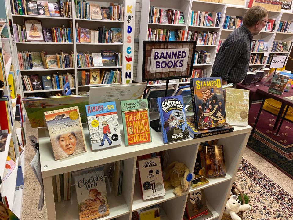 NewSouth Bookstore co-owner Randall Williams is shown near a display of books that have been banned by some schools, including "Charlotte's Web" and "Captain Underpants."
