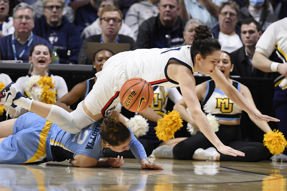 Connecticut's Lou Lopez Senechal, top, is fouled by Marquette's Chloe Marotta during the first half of an NCAA college basketball game in the semifinals of the Big East Conference tournament at Mohegan Sun Arena, Sunday, March 5, 2023, in Uncasville, Conn. (AP Photo/Jessica Hill)