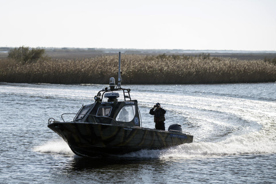 Police border guards on a boat patrol along the Evros River that forms a natural border between Greece and Turkey, on Sunday, Oct. 30, 2022. Greece is planning a major extension of a steel wall along its border with Turkey in 2023, a move that is being applauded by residents in the border area as well as voters more broadly. (AP Photo/Petros Giannakouris)
