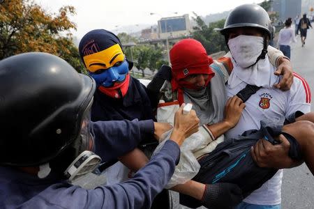 Un manifestante herido es ayudado durante enfrentamientos con fuerzas de seguridad mientras protestan contra el Gobierno del presidente venezolano Nicolás Maduro en Caracas, Venezuela, 24 de abril de 2017. REUTERS/Carlos Garcia Rawlins - RTS13R2V