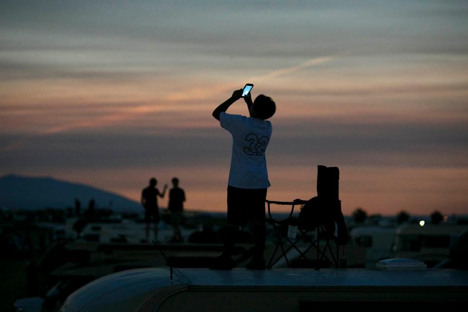 Spectators photograph totality during the 2017 eclipse from the roof of their RVs in Solartown, a solar eclipse campground in Madras, Ore.