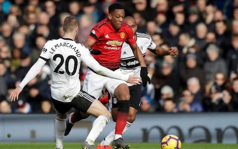 Manchester United's Anthony Martial, center, duels for the ball with Fulham's Maxime Le Marchand, left, during the English Premier League soccer match between Fulham and Manchester United at Craven Cottage - Credit: AP