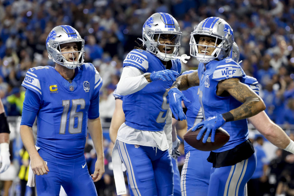 Detroit Lions wide receiver Josh Reynolds (8) receives congratulations from teammates after scoring in the first half against the Tampa Bay Buccaneers during an NFL divisional round playoff football game Sunday, Jan. 21, 2024, in Detroit. (AP Photo/Rick Osentoski)