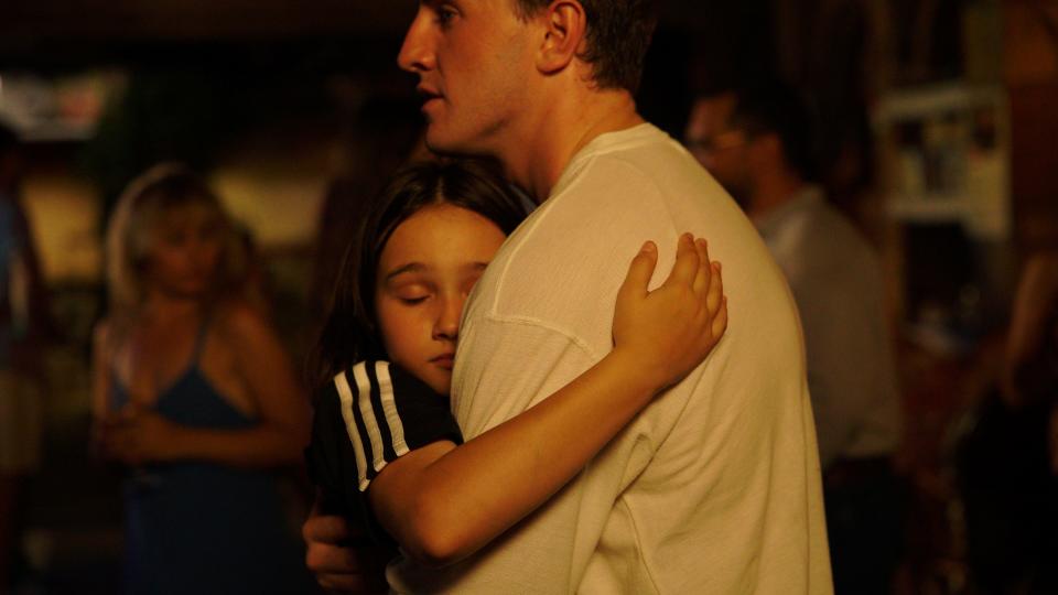 Sophie (Frankie Corio, left) hugs Calum (Paul Mescal) on the dance floor in "Aftersun."