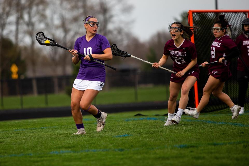 West Ottawa's Ella Spooner takes the ball to the sideline during a game against Grandville Friday, April 30, 2022, at West Ottawa Panther Stadium. 