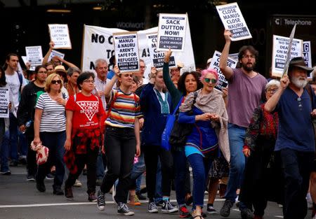 Refugee advocates hold placards as they participate in a protest in central Sydney, against the treatment of asylum-seekers in detention centres located in Nauru and on Manus Island, Australia, October 15, 2017. REUTERS/David Gray