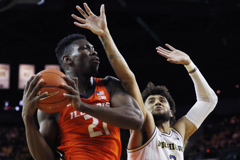 Illinois center Kofi Cockburn, left, grabs a rebound next to Michigan forward Isaiah Livers, right, during the first half of an NCAA college basketball game, Saturday, Jan. 25, 2020, in Ann Arbor, Mich. (AP Photo/Carlos Osorio)