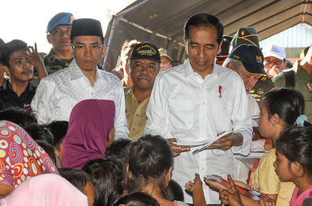 Indonesian President Joko Widodo (R) stands beside Nusa Tenggara Barat Governor TGB Zainul Majdi while talking to earthquake victims inside a makeshift tent at Madayin village in Lombok Timur, Indonesia, July 30, 2018. Antara Foto/Ahmad Subaidi/via REUTERS