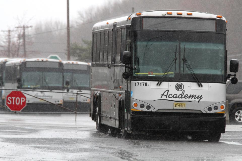 Academy buses sit idle in their depot along Route 36 in Middletown Monday, March 23, 2020.