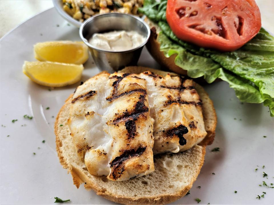 A grilled grouper sandwich with a side of corn salad at Harry's Restaurant on Longboat Key photographed July 8, 2023.