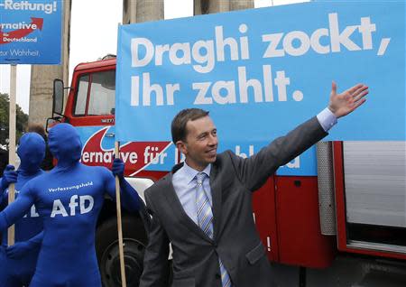 Bernd Lucke, the leader of the euro-critical Alternative for Germany party (AFD) gestures in front of a campaign poster during an election campaign rally in Berlin September 16, 2013. REUTERS/Fabrizio Bensch