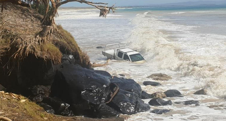 Onlookers and the towing company could only watch on and wait for the tide to subside. Source: Facebook/Rainbow Beach Towing & Roadside Assist