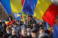 Anti-vaccination protesters rally outside the parliament building in Bucharest, Romania, Sunday, March 7, 2021. Some thousands of anti-vaccination protestors from across Romania converged outside the parliament building protesting against government pandemic control measures as authorities announced new restrictions amid a rise of COVID-19 infections. (AP Photo/Vadim Ghirda)