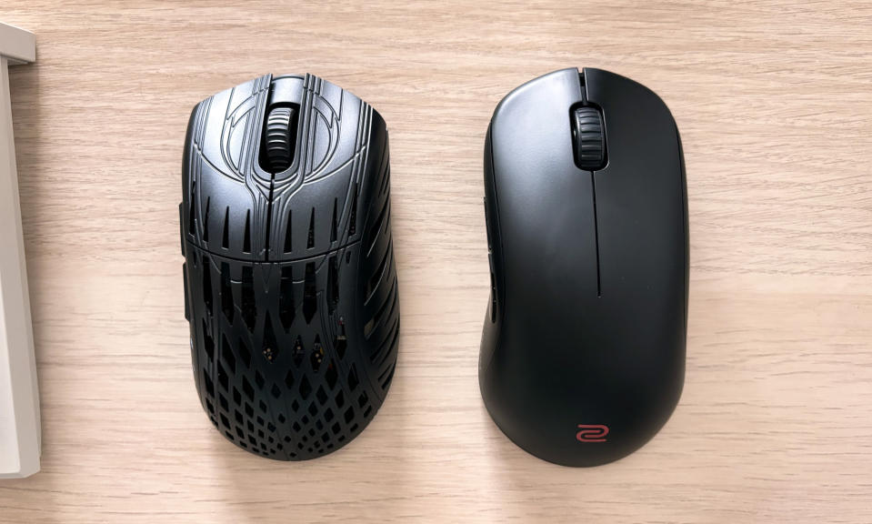 The Pwnage Stormbreaker and BenQ Zowie U2 gaming mice side-by-side on a brown wooden desktop.