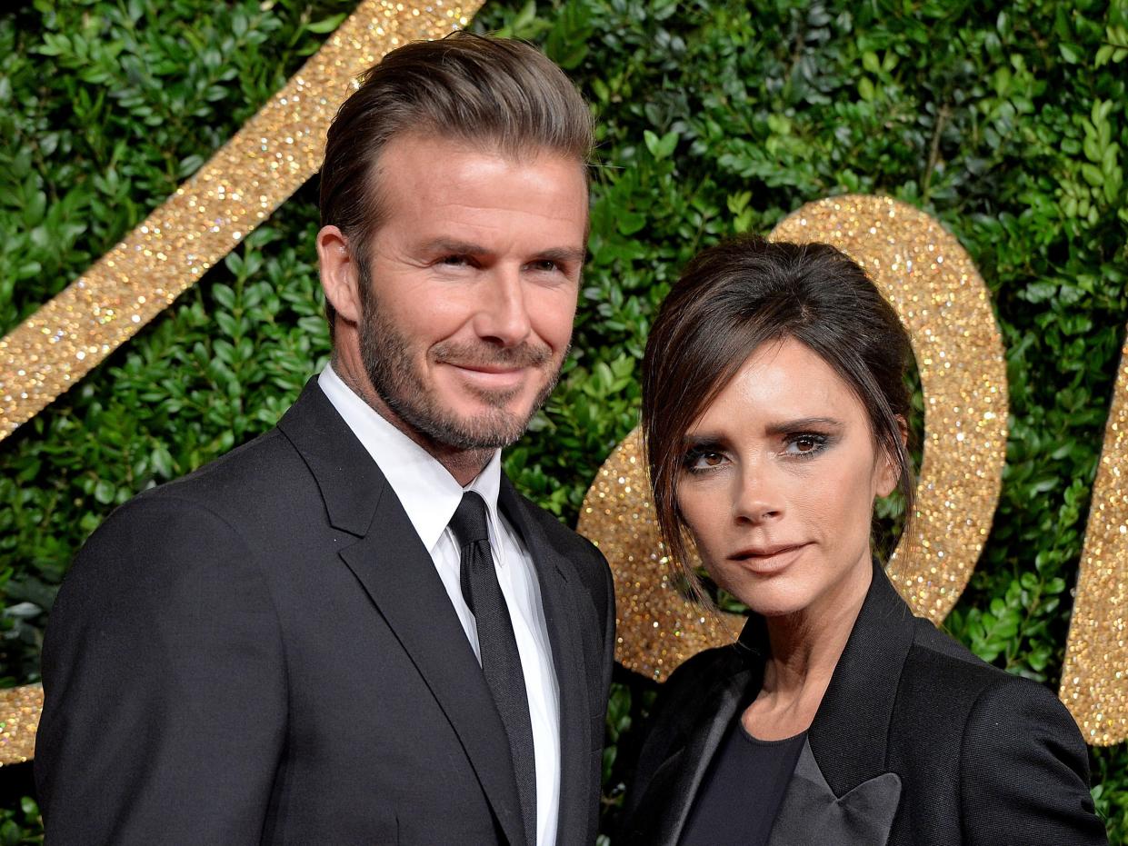 David and Victoria Beckham posing for a photo at an awards show.