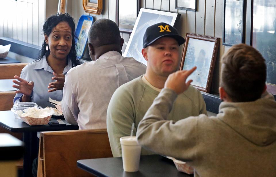 Judi Chambers, facing, chats with Dr. Michael Atta over lunch at Diamond Deli in downtown Akron on Jan. 26.