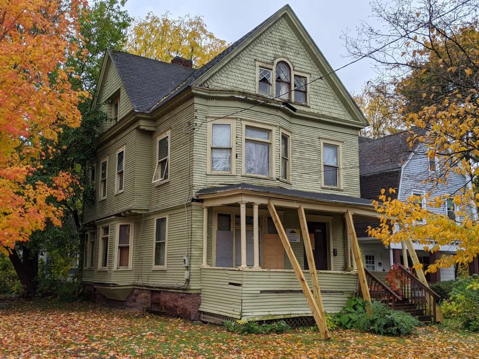 The exterior of an abandoned Victorian house.