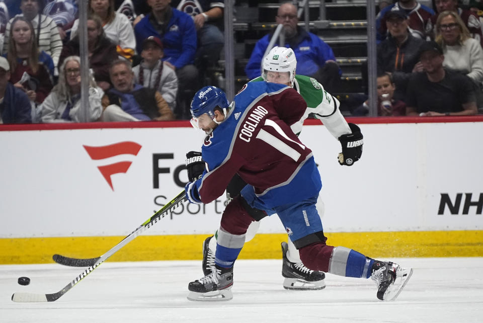 Colorado Avalanche center Andrew Cogliano, front, puts a shot on the net as Dallas Stars' Ryan Suter defends during the second period of Game 3 of an NHL hockey Stanley Cup playoff series Saturday, May 11, 2024, in Denver. (AP Photo/David Zalubowski)