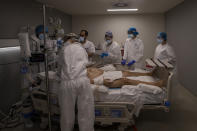 A medical team of the new Nurse Isabel Zendal Hospital perform a fiberoptic bronchoscopy to a patient of the COVID-19 ICU ward in Madrid, Spain, Monday, Jan. 18, 2021. As the coronavirus curve of contagion turned increasingly vertical after Christmas and New Year's, the Zendal has been busy. On Monday, 392 virus patients were being treated, more than in any other hospital in the Madrid region. (AP Photo/Bernat Armangue)