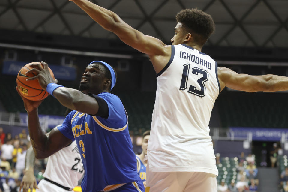 UCLA forward Adem Bona (3) goes to the net over Marquette forward Oso Ighodaro (13) during the second half of an NCAA college basketball game, Monday, Nov. 20, 2023, in Honolulu. (AP Photo/Marco Garcia)