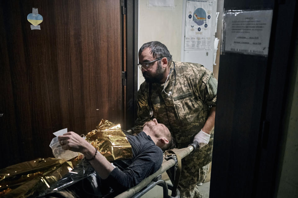 Ukrainian soldiers carry a wounded soldier into a hospital in Bakhmut, Donetsk region, Ukraine, Wednesday, Nov. 9, 2022. (AP Photo/LIBKOS)