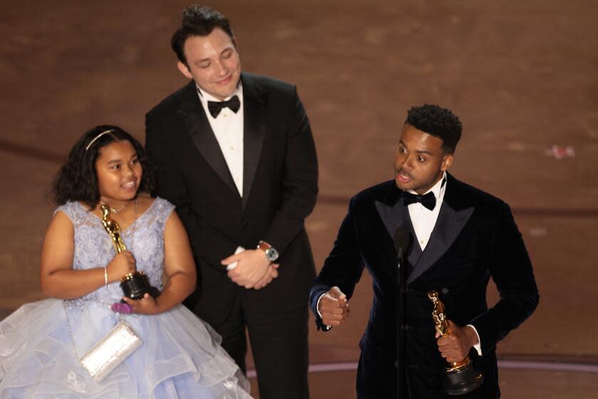 Hollywood, CA - March 10: Ben Proudfoot (C), Porche Brinker (L) and Kris Bowers during the live telecast of the 96th Annual Academy Awards in Dolby Theatre at Hollywood & Highland Center in Hollywood, CA, Sunday, March 10, 2024. (Myung J. Chun / Los Angeles Times)