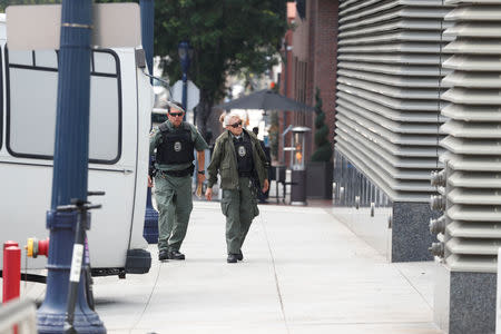 Detention officers walk outside a building, as asylum seekers from Tijuana, Mexico are brought to the United States for their immigration hearing at a court in San Diego, California, U.S., March 19, 2019. REUTERS/ Mike Blake