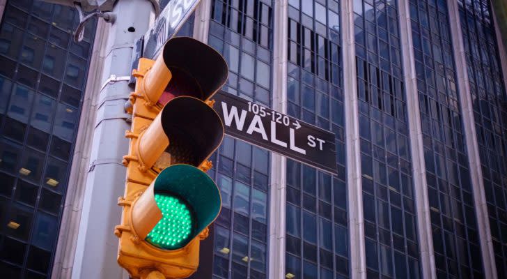 A traffic light flashes green in front of Wall Street.