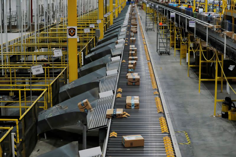 FILE PHOTO: Amazon packages are pushed onto ramps leading to delivery trucks by a robotic system as they travel on conveyor belts inside of an Amazon fulfillment center on Cyber Monday in Robbinsville, New Jersey