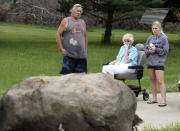 Paul Corsi Jr., left, his mother Tressie Corsi and Stacey Walker, the girlfriend of Corsi's great grandson Andrew, watch as a rock that has become an emotional landmark outside of the house Tressie Corsi has owned in Johnstown, Ohio, since 1972 that she is giving up to make way for an Intel manufacturing plant during an interview Monday, June 20, 2022. Her son, Paul Corsi Jr., lived next door on 3 acres where he was raising two grandchildren. He's relocating to 14 acres where he and his mother will live. (AP Photo/Paul Vernon)