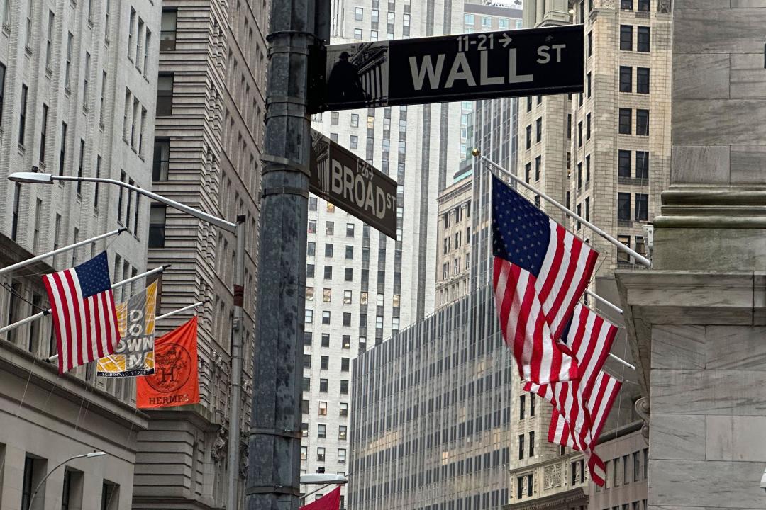 FILE - American flags hang from the front the New York Stock Exchange, right, on April 11, 2024 in New York. Global shares are trading higher on Friday, May 10, 2024, after a rally on Wall Street that pulled the S&P 500 back within 1% of its record. (AP Photo/Peter Morgan, File)