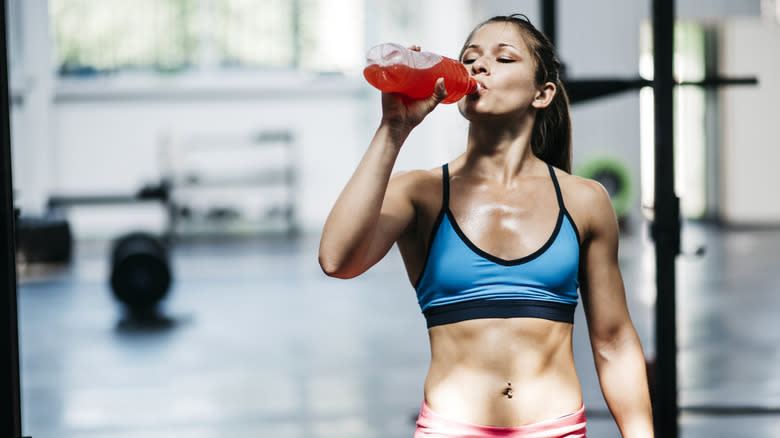 Woman drinking sports drink in gym