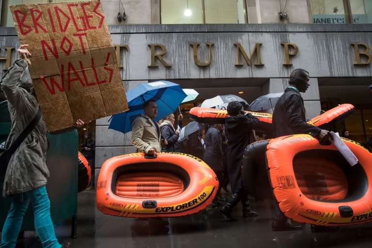 People carry rafts, signifying the struggle of refugees, as they march on Wall Street during a protest against the Trump administration's proposed travel ban and refugee policies, in New York, on March 28, 2017