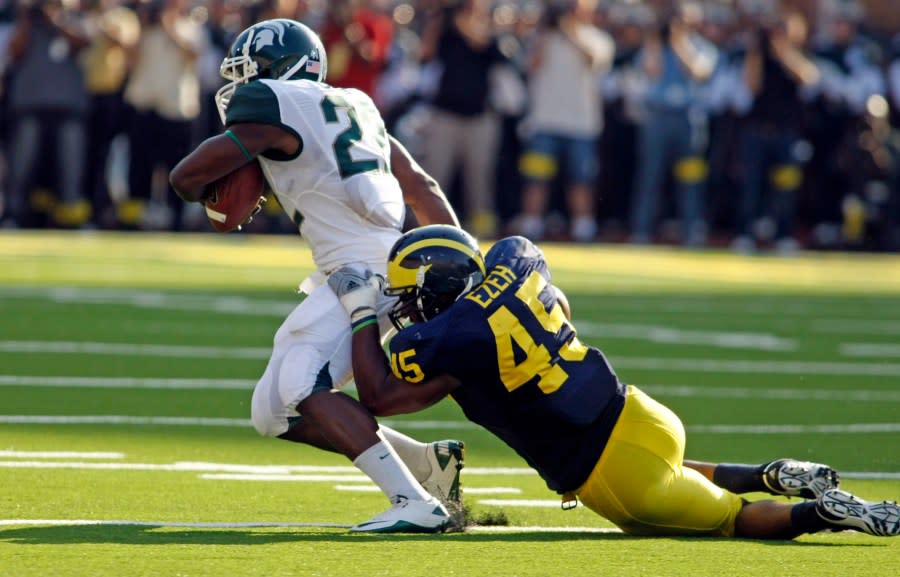 In this 2010 file photo, Michigan linebacker Obi Ezeh tries to tackle Michigan State running back Larry Caper. (AP file)