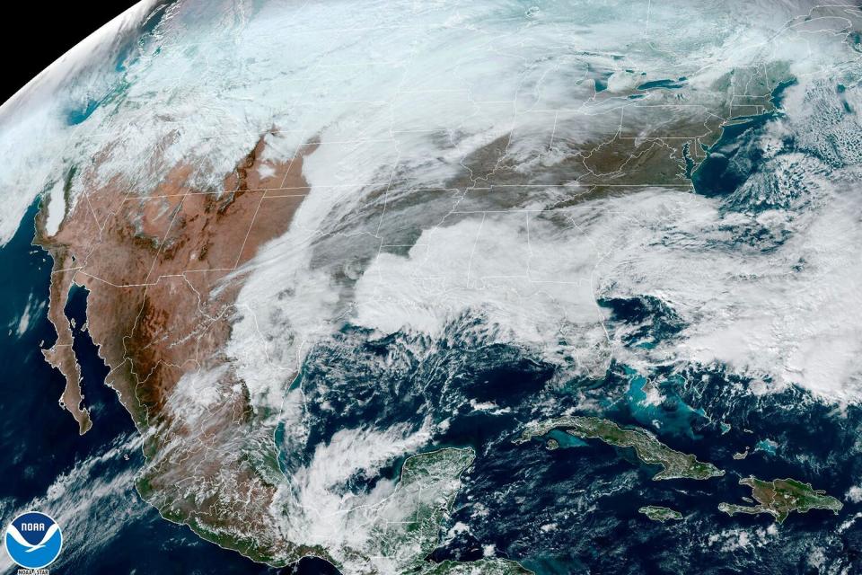 This satellite image made available by NOAA shows cloud cover over North America on at 1:31 p.m. An arctic blast is bringing extreme cold, heavy snow and intense wind across much of the U.S. this week - just in time for the holidays