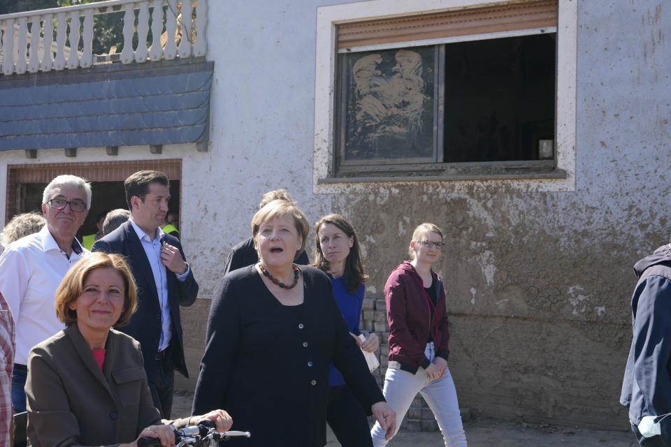 German Chancellor Angela Merkel, center, and Malu Dreyer, left, Prime Minister of Rhineland-Palatinate, talk to residents during their visit to the flood-damaged district Altenburg, part of the municipality of Altenahr, Germany, Friday, Sept. 3, 2021. After days of extreme downpours causing devastating floods hit the valley of the river Ahr in July. (AP Photo/Markus Schreiber, Pool)