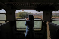 A woman looks out of a window from of a train traveling through the outskirts of Damascus towards recently opened international fair in Damascus, Syria, September 15, 2018. REUTERS/Marko Djurica