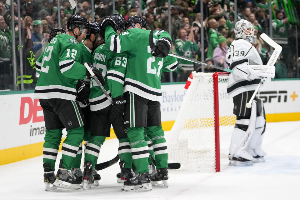 Los Angeles Kings goaltender Cam Talbot, right, looks on as Dallas Stars players celebrate a goal by right wing Evgenii Dadonov (63) during the first period of an NHL hockey game, Tuesday, Jan. 16, 2024, in Dallas. (AP Photo/Julio Cortez)