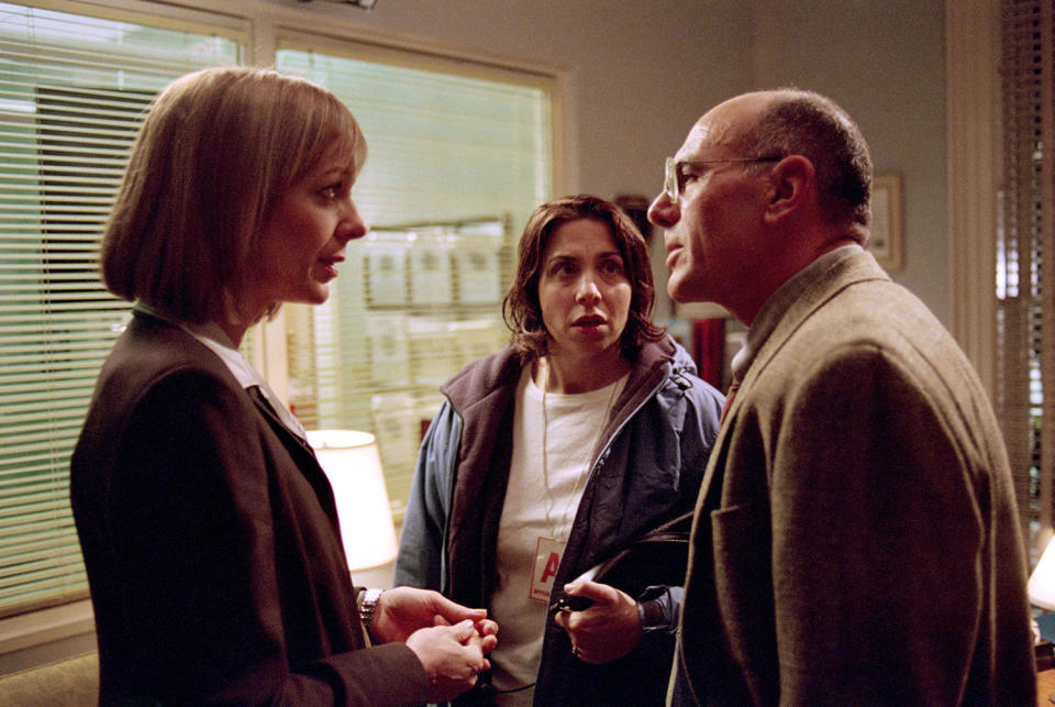 Allison Janney as C.J. talking with Carmen Argenziano as Leonard Wallace as Nancy Cassaro as Janet Price looks on. (© Warner Bros. Entertainment, Inc.)