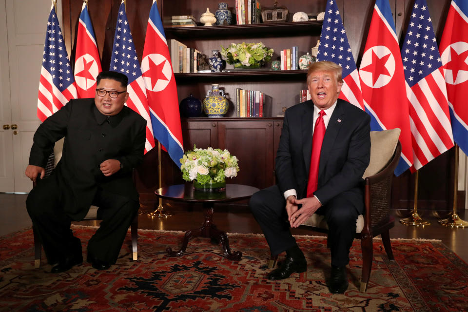 President Donald Trump sits next to North Korea's Kim Jong Un before their meeting in Singapore on June 12, 2018.