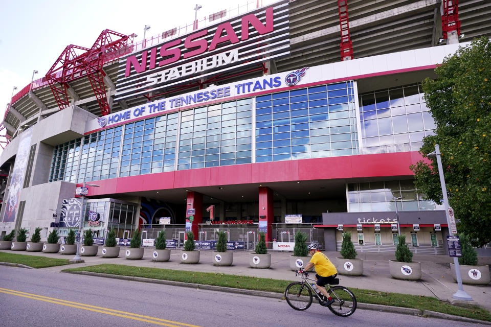 A cyclist passes by Nissan Stadium, home of the Tennessee Titans, Tuesday, Sept. 29, 2020, in Nashville, Tenn. The Titans suspended in-person activities through Friday after the NFL says three Titans players and five personnel tested positive for the coronavirus, becoming the first COVID-19 outbreak of the NFL season in Week 4. (AP Photo/Mark Humphrey)