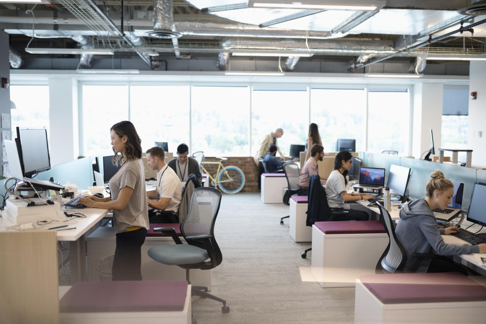 Creative business people working at computers in open plan office